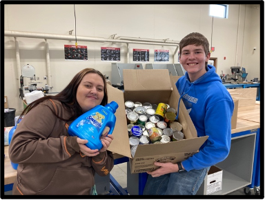 Members Anna and Layne pose with some donated food items.